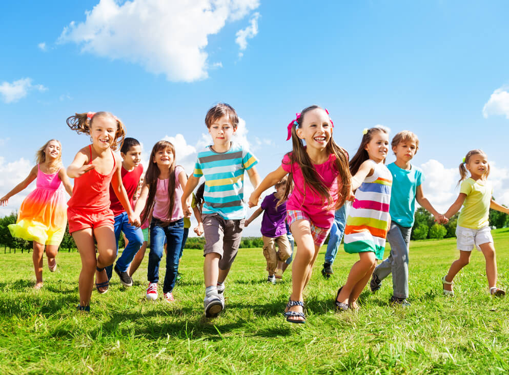 viele Kinder rennen auf einer Wiese