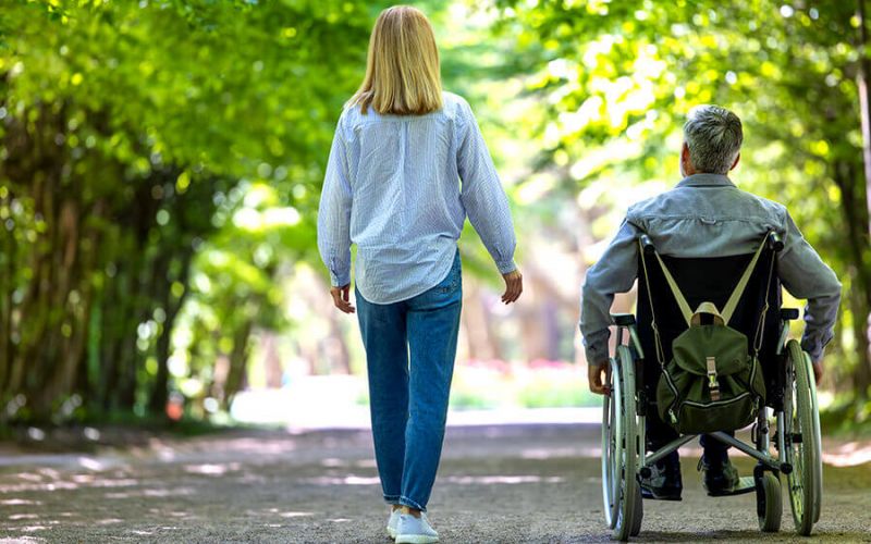 Mann im Rollstuhl im Park von hinten